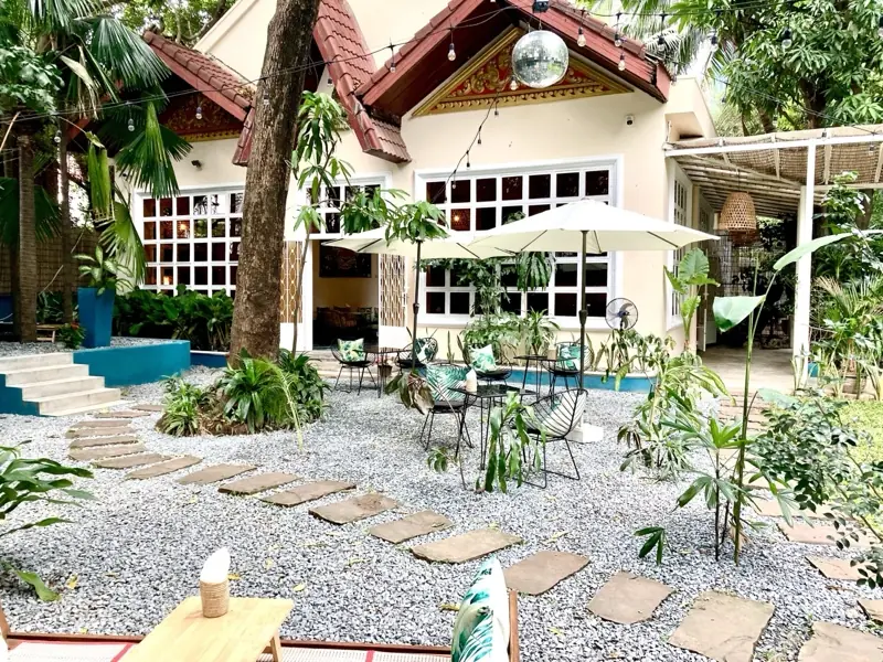 The garden of WILD Phnom Penh, colonial house and dense greenery